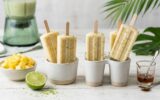 Gelados de Abacaxi e Coco em Notícias Gelados de abacaxi artesanais com raspas de lima, servidos ao lado de fruta fresca, xarope de ácer e um liquidificador.